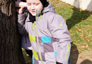 Jasio słucha drzewa przez papierową rolkę.